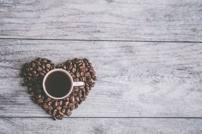 Heart made of coffee beans on desk