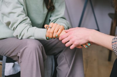 Person holding a hand in sympathy