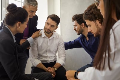 Group of coworkers offering condolences messages to colleague
