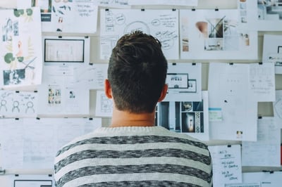 Man sitting in front of a mind map on a bulletin board