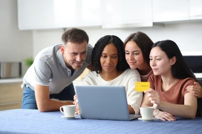 Four people working on group gifting online around a laptop