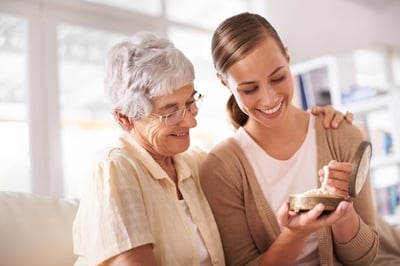 A mother wishing happy birthday to her daughter and giving a gift in a jewelry box
