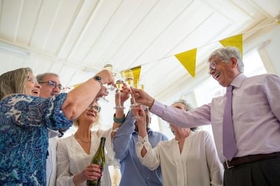 A group of older celebrants at a retirement farewell party, toasting.