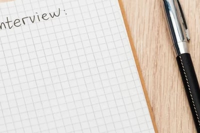 An employee struggles to create a list of effective exit interview questions, leaving the numbered list blank.