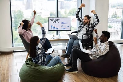Coworkers celebrate a shared project success in a bright office