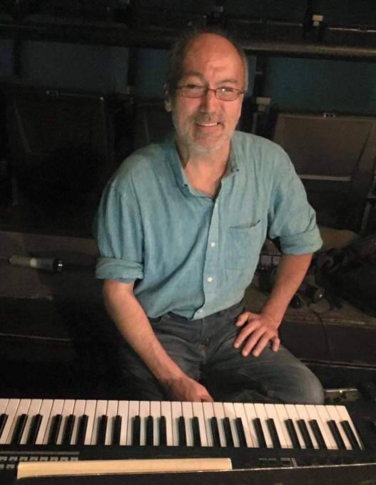 George in front of piano