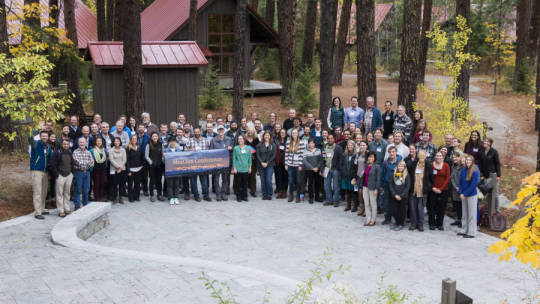 Group of employees holding banner together in the woods