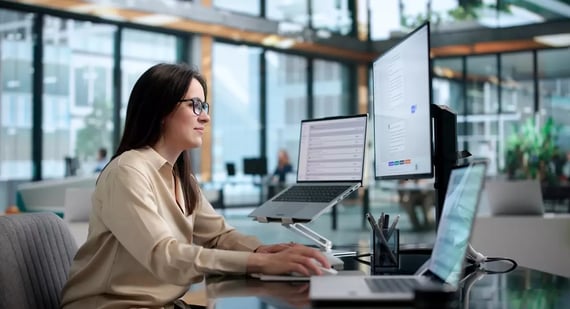 A young woman uses multiple internal communication tools to keep up with work and fellow employees.