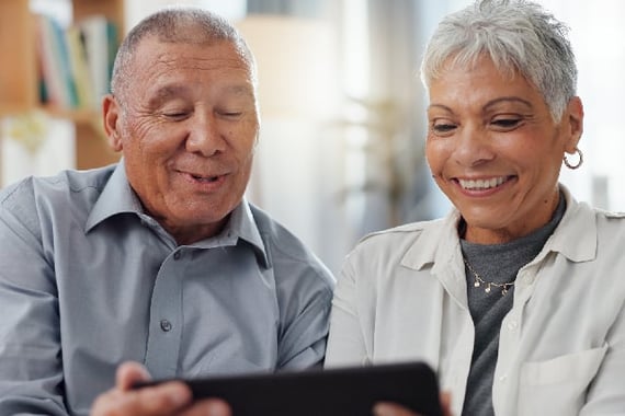 Retirees looking a retirement wishes on a tablet