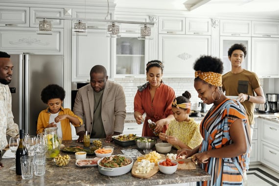 Group of people making food together in kitchen