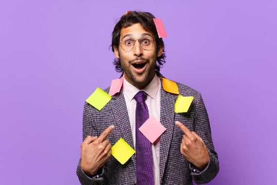 man covered in employee recognition notes pointing to himself