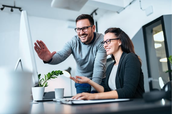 Two employees talking about what is a group eCard on a computer