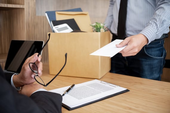 Employee giving a resignation letter to his manager.