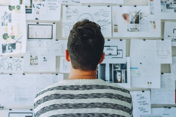 Man sitting in front of a mind map on a bulletin board