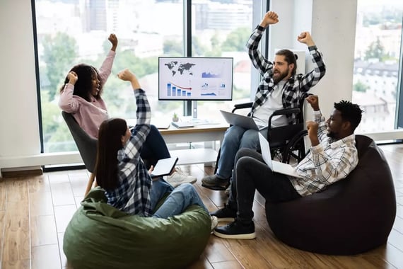 Coworkers celebrate a shared project success in a bright office