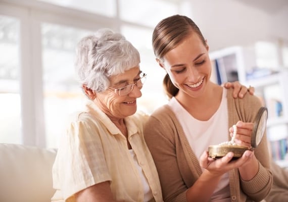 A mother wishing happy birthday to her daughter and giving a gift in a jewelry box