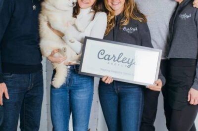 Group of people and dog posing with Carely's Angels sign
