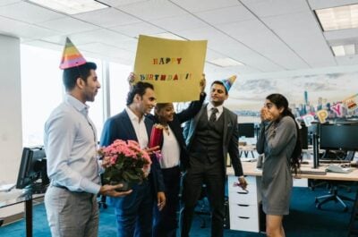 Person surprised with office party from coworkers