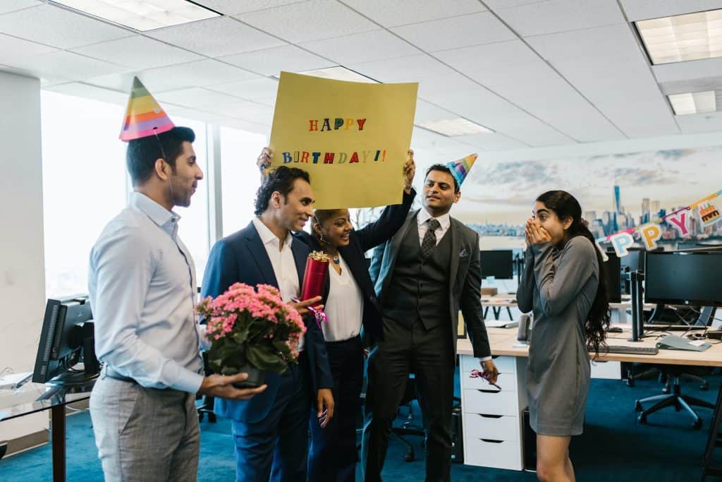 Person surprised with office party from coworkers