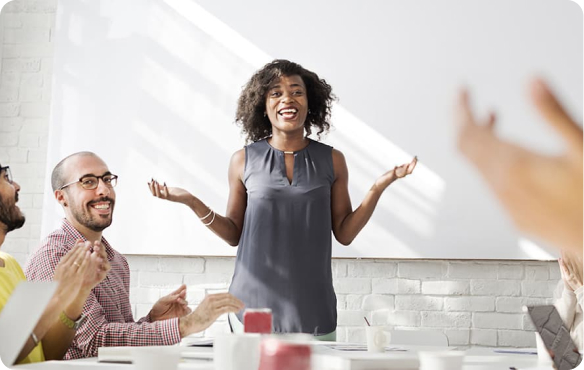 People applauding woman in meeting room