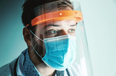 Close up of healthcare worker wearing mask and face shield