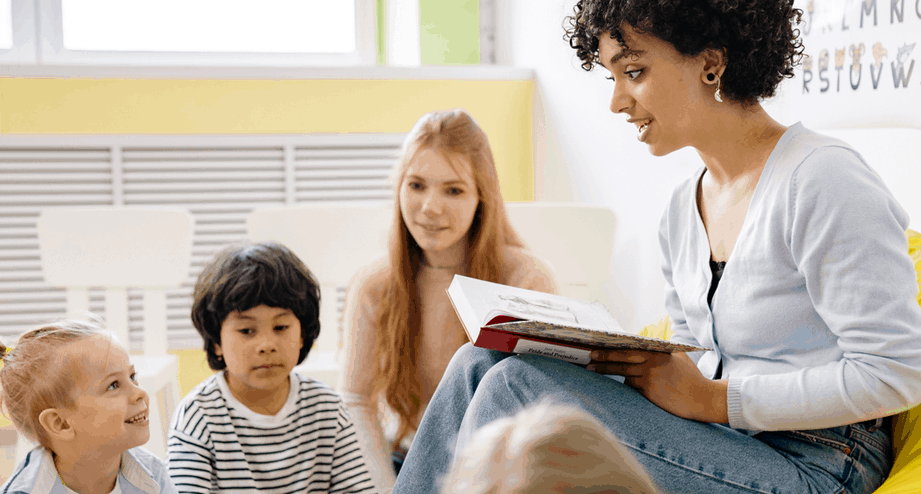 Teacher reading book aloud to group of students