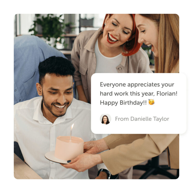 Office workers delivering cake with lit candle and a