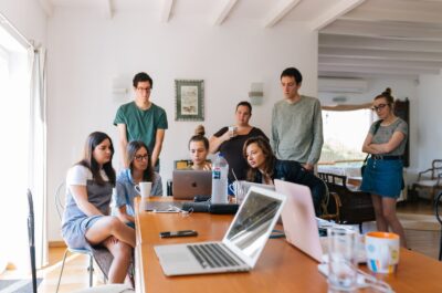 People standing around and looking at laptop