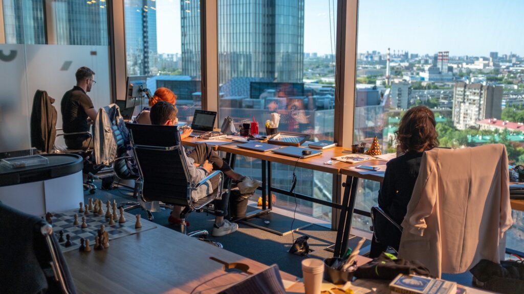 Group of employees working on table in front of open window