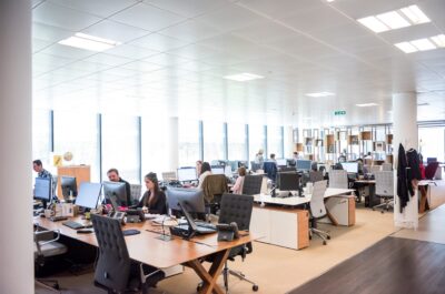 Crowded office with monitors and people