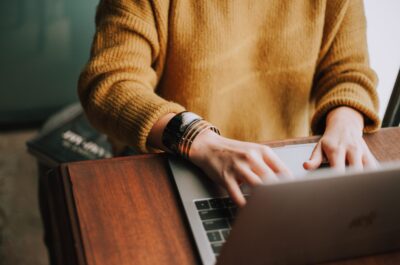 Hands typing on laptop