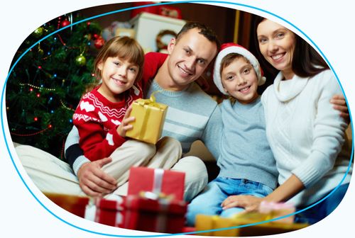 Family posing for photo in front of Christmas tree