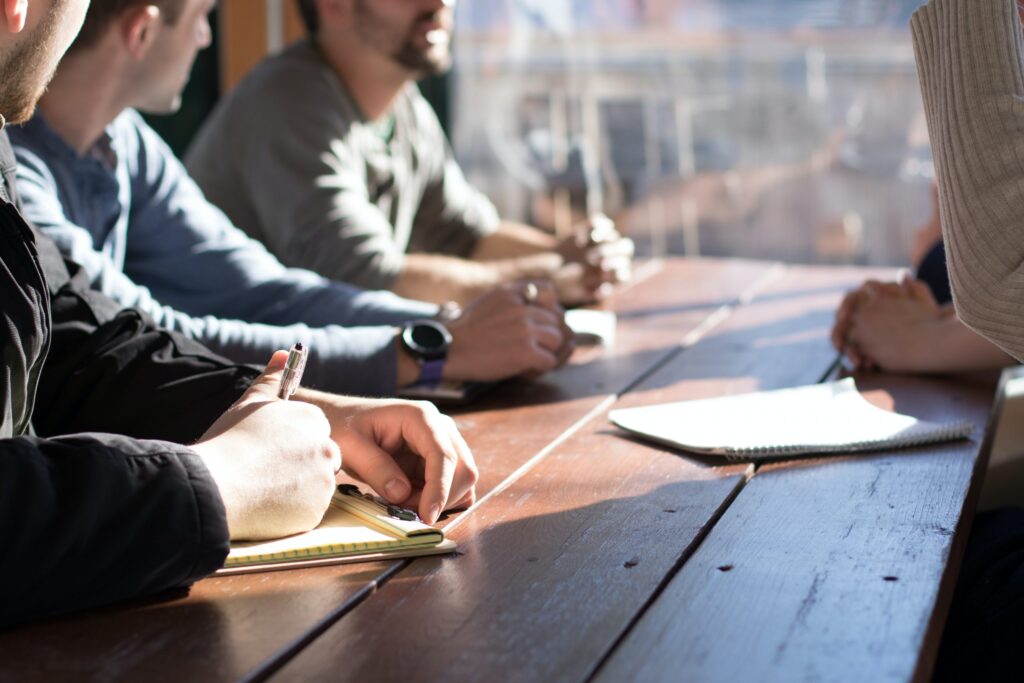 Group of people talking and writing on notepad