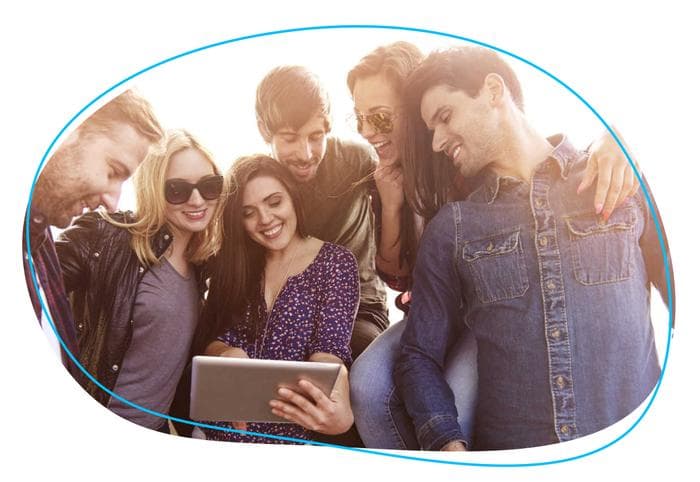 Group of people smiling and looking at tablet