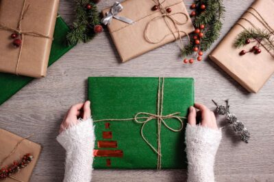 Person holding wrapped Christmas gifts