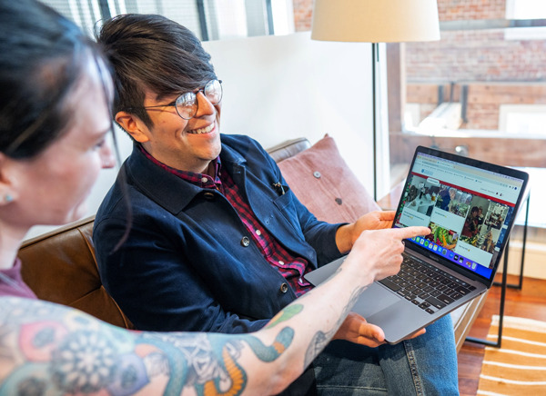 People on couch looking at Kudoboard on laptop