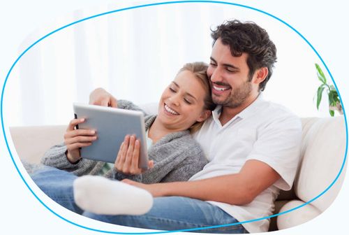 Couple sitting on couch looking at tablet