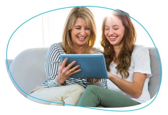 Mother and daughter smiling at tablet