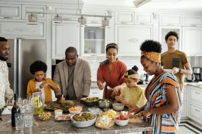 Group of people making food together in kitchen