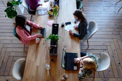 People working on laptops and notebooks at long conference table