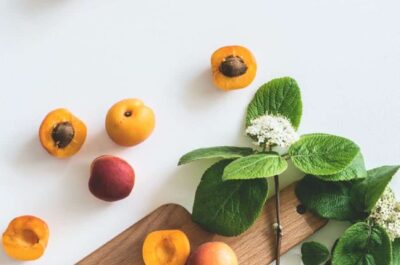 Sliced apricots on cutting board with greenery