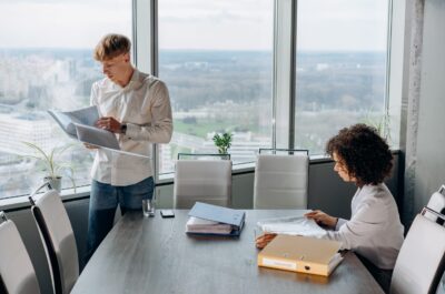 Two office workers reviewing files at table