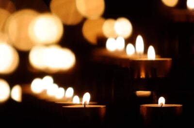 Votive candles burning in dark room