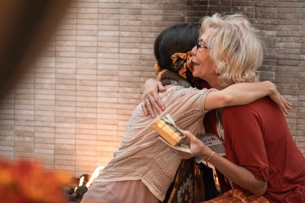 Older woman holding gift and hugging someone