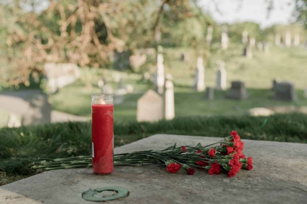 Candle and flowers on gravestone