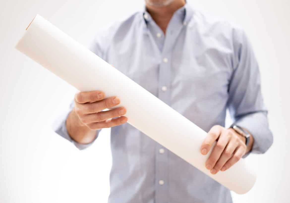 Person holding a rolled up Kudoboard poster