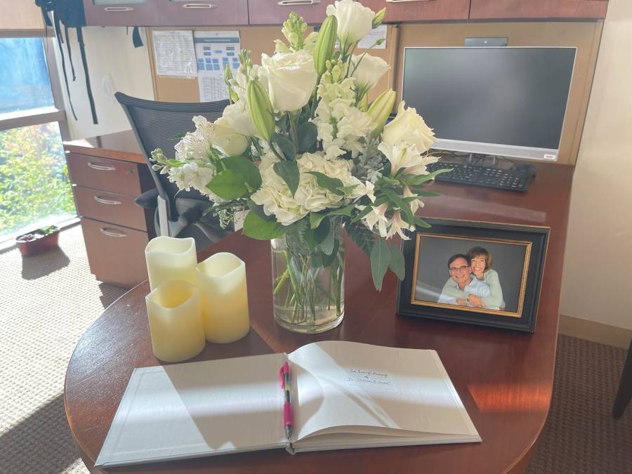 Sympathy flowers on desk and book with pen