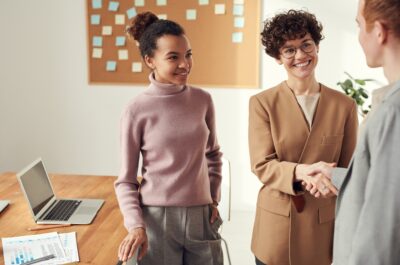 Office workers smiling and shaking hands