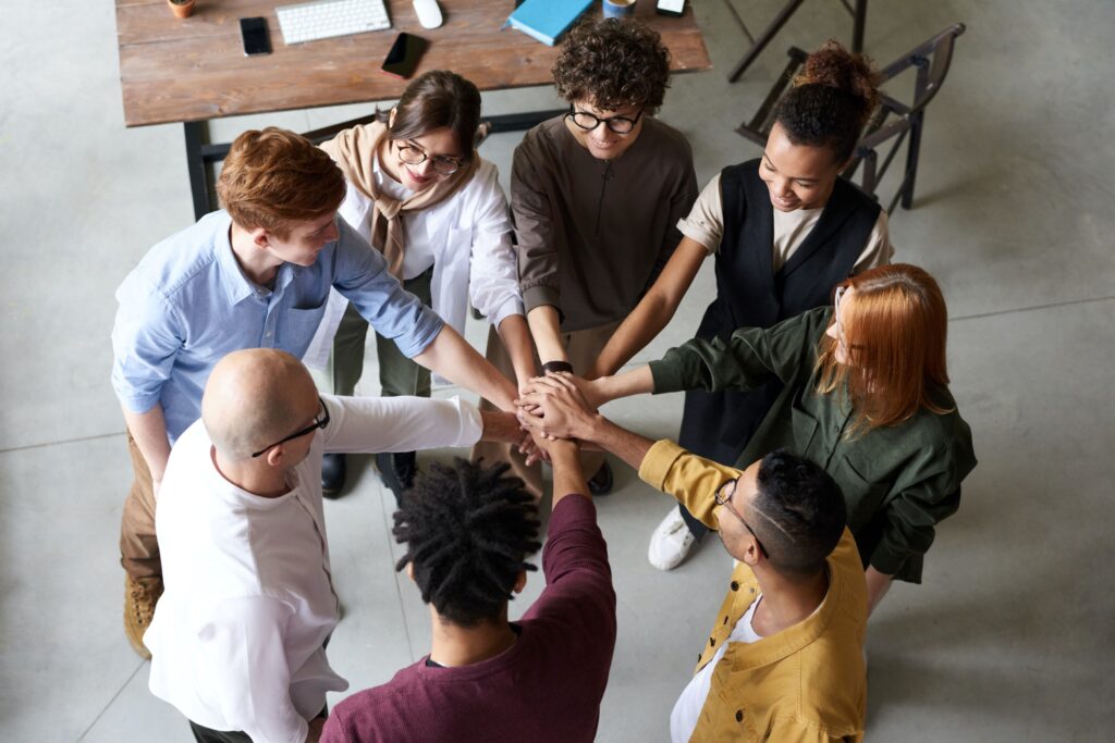 Group of people in office holding hands in circle