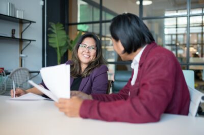 Two people working together on paperwork in office